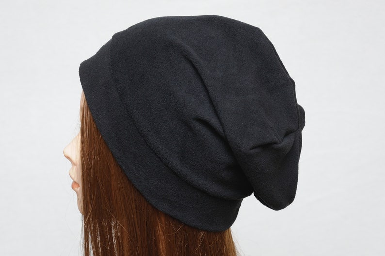 May include: A black slouchy beanie hat made of soft fleece fabric.