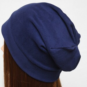 May include: A navy blue slouchy beanie hat made of soft fleece fabric.