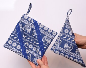 May include: Two blue and white pot holders with an elephant print. One is square and the other is triangular.