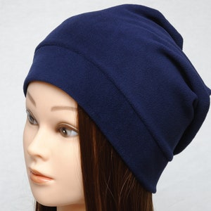 May include: A navy blue fleece beanie hat. The hat is folded down at the top, creating a slouchy look.