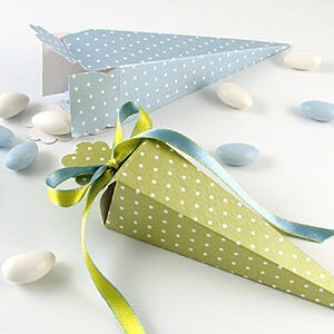 May include: Two cone-shaped party favor boxes, one light blue with white polka dots and one green with white polka dots. Both boxes have a ribbon tied around them.