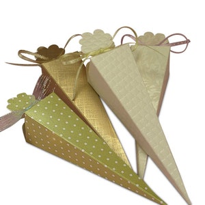 May include: Three cone-shaped paper party favor boxes with different patterns. The boxes are decorated with a gold, green, and white polka dot pattern, a gold and white textured pattern, and a white embossed pattern. Each box has a ribbon and a decorative flower.