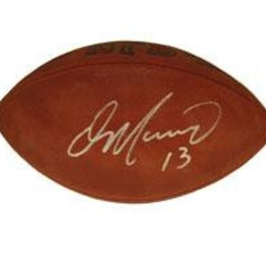 May include: A brown football signed by a player with the number 13. The signature is in white ink.