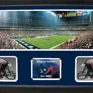Puede incluir: Un collage de fotos enmarcado que presenta una vista panorámica de un estadio de fútbol con una multitud de fanáticos, un logotipo de equipo y dos cascos de fútbol. El texto "HOUSTON TEXANS Est. 2002" se muestra en la parte inferior del collage.