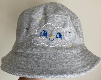 Happy Cloud Hut: Handbestickter Fischerhut für Frauen, grauer Frottee Hut mit niedlichem lächelndem Gesicht, Kawaii Regenwolke Stickerei Design