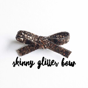 May include: A small, skinny, brown glitter bow. "skinny glitter bow" is written below the bow.