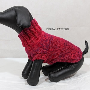 May include: A red and purple knitted dog sweater with a high neck. The sweater is on a black mannequin dog.