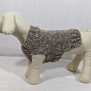 Puede incluir: Un su&eacute;ter de punto marr&oacute;n y blanco para perro en un maniqu&iacute; blanco.