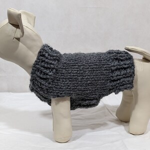 Puede incluir: Jersey de punto gris para perro en un maniqu&iacute; blanco. El jersey es de dise&ntilde;o sencillo con una textura acanalada.