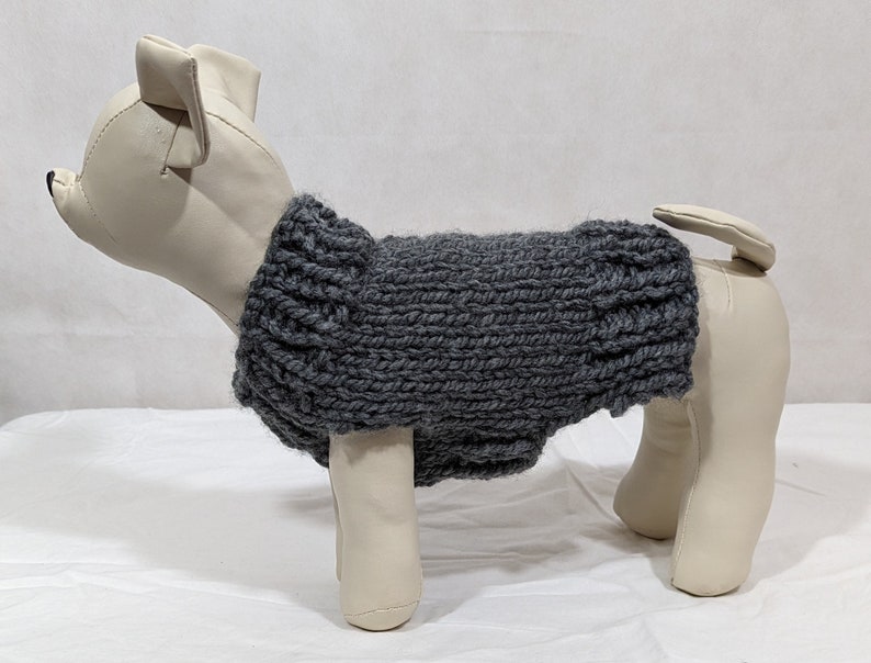 Puede incluir: Jersey de punto gris para perro en un maniqu&iacute; blanco. El jersey es de dise&ntilde;o sencillo con una textura acanalada.