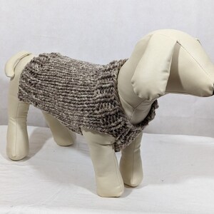 Puede incluir: Un su&eacute;ter de punto para perro de color marr&oacute;n y blanco con cuello alto.
