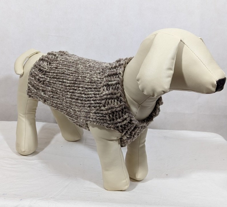 Puede incluir: Un su&eacute;ter de punto para perro de color marr&oacute;n y blanco con cuello alto.