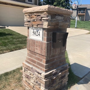 Puede incluir: Un buz&oacute;n de ladrillo con una fachada de piedra y una placa de n&uacute;mero de casa que dice "5024".