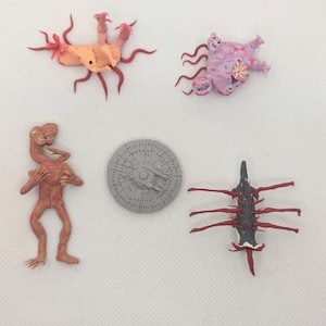 May include: Five small, hand-painted, plastic figurines of various creatures. The creatures are red, orange, pink, and gray. The figurines are on a white background.