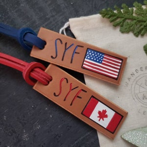May include: Two leather keychains with the initials "SYF" and the flags of the United States and Canada.