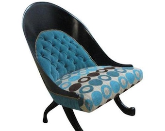 May include: A black and blue upholstered armchair with a tufted back and a patterned seat. The chair has a unique, curved design and a set of four legs.