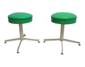 May include: Two green upholstered stools with white metal bases and a star-shaped base.