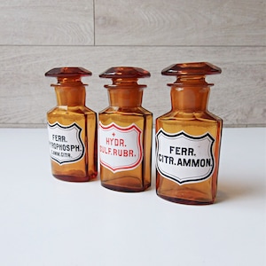 Three brown glass pharmacy bottles