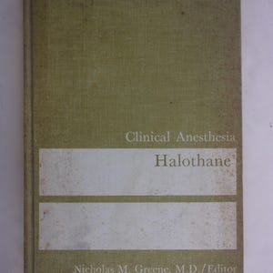 May include: A hardcover book titled "Clinical Anesthesia Halothane" with a light green cover. The title and author's name are printed in a darker green font. The book has a white rectangular label with the title "Halothane".