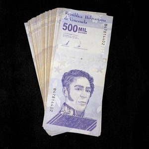 May include: A stack of Venezuelan banknotes, each featuring a portrait of a man and the text "500 MIL BOLIVARES" and "República Bolivariana de Venezuela".