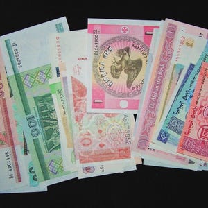 May include: A collection of colorful banknotes, featuring various denominations and designs. The bills display a range of colors, including red, green, pink, and blue, with intricate patterns and text. The banknotes are arranged against a black background.