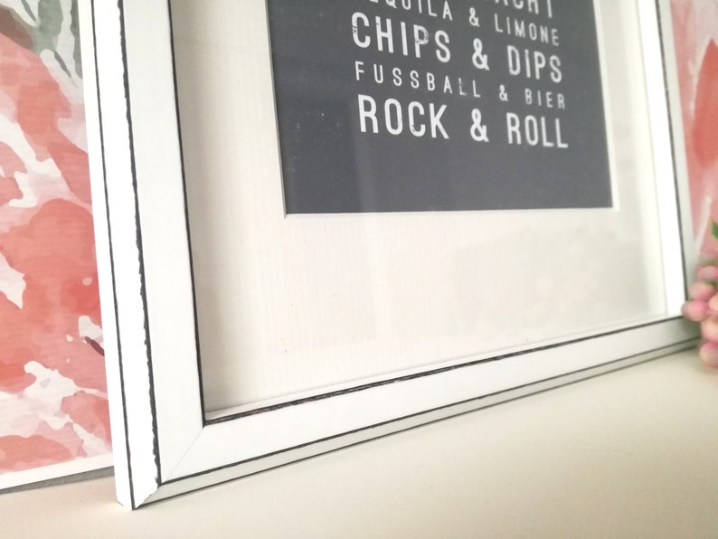 Puede incluir: Marco de imagen blanco con una impresi&oacute;n en blanco y negro en el interior. La impresi&oacute;n dice "Tequila & Limone, Chips & Dips, Fussball & Bier, Rock & Roll".