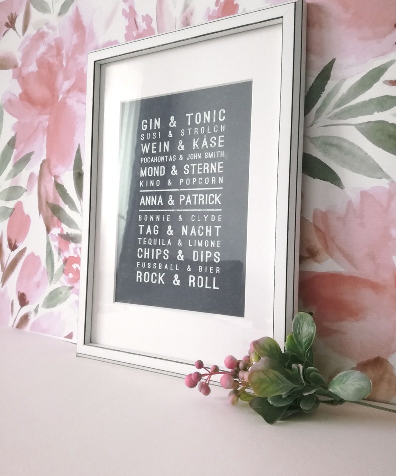 Puede incluir: Una impresi&oacute;n enmarcada en blanco con fondo negro y texto blanco. El texto dice "Gin & Tonic, Susi & Strolch, Wein & Kase, Pocahontas & John Smith, Mond & Sterne, Kino & Popcorn, Anna & Patrick, Bonnie & Clyde, Tag & Nacht, Tequila & Limone, Chips & Dips, Fussball & Bier, Rock & Roll".