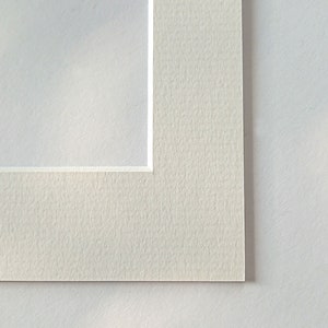 Puede incluir: Primer plano de la esquina de una cartulina blanca con una superficie texturizada.
