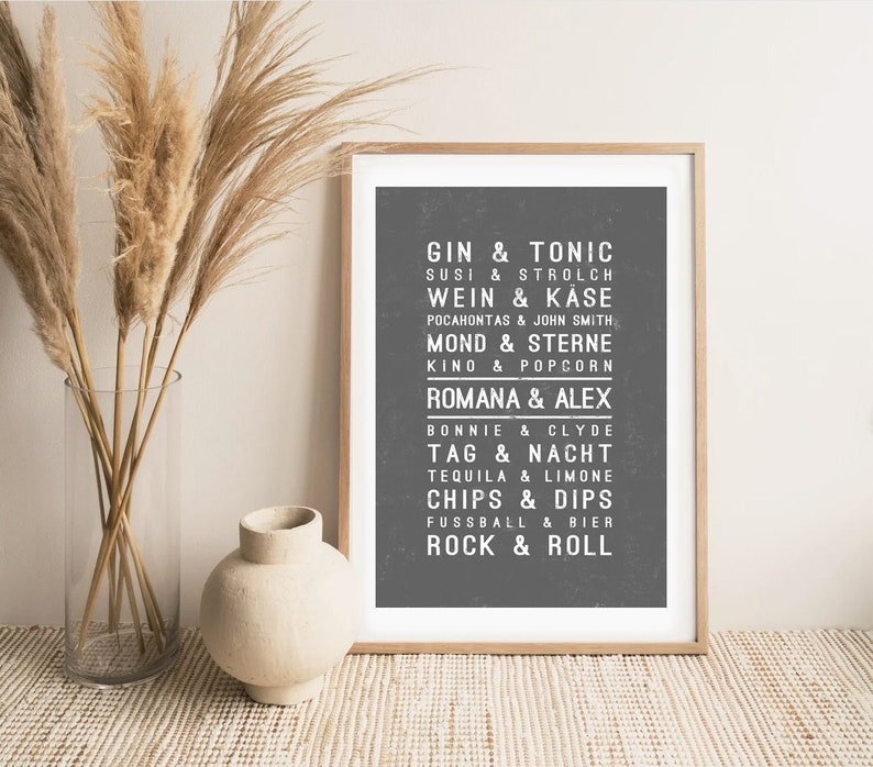 May include: A black and white printable wall art print with a list of phrases in a vintage style font. The phrases include "Gin & Tonic", "Susi & Strolch", "Wein & K&auml;se", "Pocahontas & John Smith", "Mond & Sterne", "Kino & Popcorn", "Romana & Alex", "Bonnie & Clyde", "Tag & Nacht", "Tequila & Limone", "Chips & Dips", "Fussball & Bier", and "Rock & Roll".