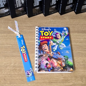 May include: A white ceramic mug with a black handle and the text "But First, Coffee" in a black, bold font. The mug is on a white surface.