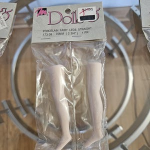 May include: A package containing two porcelain fairy doll legs. The legs are straight and measure 2 3/4 inches (70mm) in length. The packaging includes the text "Porcelain Fairy Legs Straight" and the brand name "Ms. Dolls".