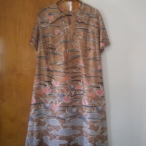 May include: A brown midi dress with a floral print featuring pink, white, and blue flowers. The dress has a V-neckline and short sleeves.