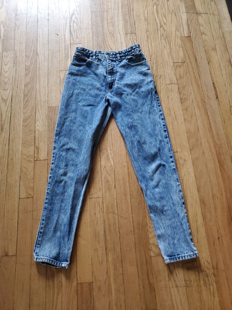 May include: Light blue acid wash denim jeans with a high waist and straight leg.