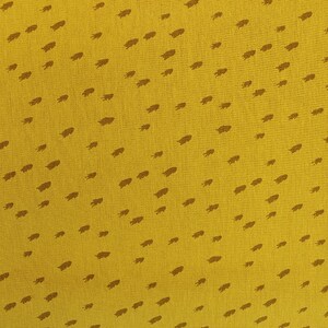 May include: Mustard yellow fabric with a repeating pattern of small, brown leaf-like shapes. A pink and white measuring tape is visible along the left side, showing measurements from 26 to 30 inches.