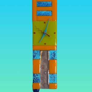 May include: A rectangular wall clock with a vibrant design. It features orange and blue accents, a lime green clock face, and a silver-colored central panel. The clock hands are blue, and the overall design is modern and artistic.
