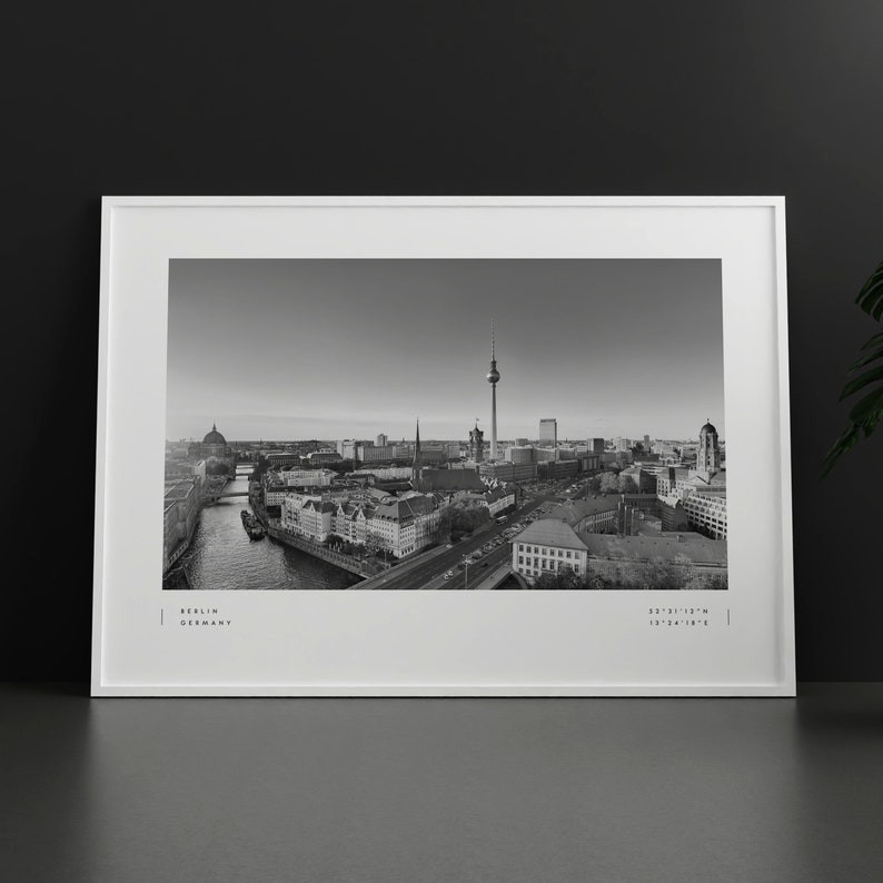 Puede incluir: Impresi&oacute;n enmarcada en blanco y negro de Berl&iacute;n, Alemania. El paisaje urbano incluye la Torre de la Televisi&oacute;n, edificios y un r&iacute;o. La impresi&oacute;n tiene el texto "Berlin Germany" y coordenadas.