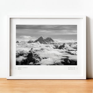 Pu&ograve; includere: Una fotografia in bianco e nero del Monte Everest, la montagna pi&ugrave; alta del mondo, con cime innevate e nuvole sullo sfondo. Il testo "MOUNT EVEREST NEPAL 27&deg;59'17"N 86&deg;55'31"E" &egrave; stampato nella parte inferiore dell'immagine.