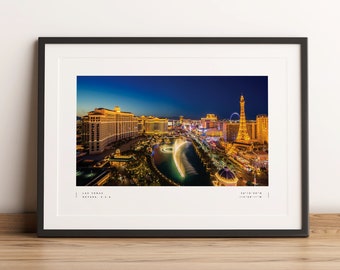 Può includere: Una vista aerea notturna dello skyline di Las Vegas, che presenta lo spettacolo delle fontane del Bellagio, la ruota panoramica High Roller e la replica della Torre Eiffel al Paris Las Vegas. La città è illuminata da luci brillanti, creando una scena vibrante e abbagliante.
