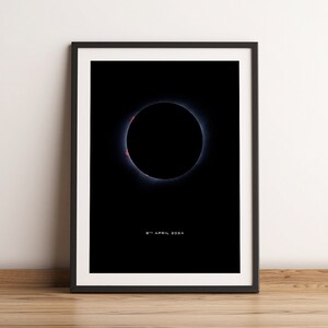 Op de afbeelding: Een zwart-witfoto van een zonsverduistering, met de corona van de zon zichtbaar rond de randen van de maan. De datum "8 april 2024" is onderaan de afbeelding gedrukt.