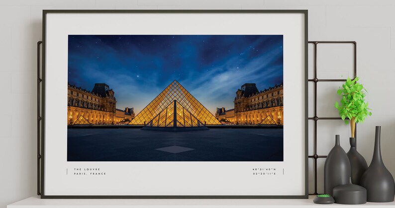 May include: A nighttime photograph of the Louvre Museum in Paris, France. The iconic glass pyramid is illuminated, with the museum building in the background. The sky is dark blue with stars visible.
