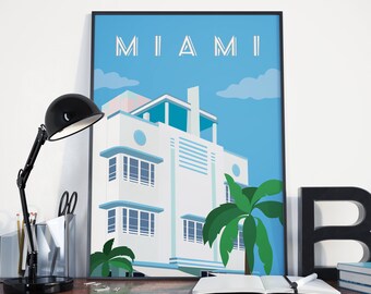 Puede incluir: Un póster enmarcado con fondo azul y la palabra "MIAMI" en letras blancas. El póster presenta un edificio blanco de estilo art déco con techo azul y palmeras en frente.