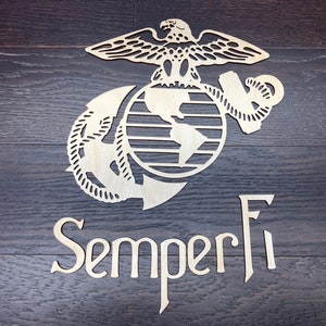 May include: A wooden cutout of the United States Marine Corps emblem, featuring an eagle, globe, and anchor. The words "Semper Fi" are displayed below the emblem.