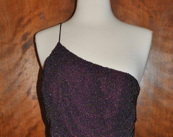 May include: A one-shoulder formal dress with a purple satin skirt and a beaded bodice. The bodice is made of small, iridescent beads in shades of purple, black, and silver.