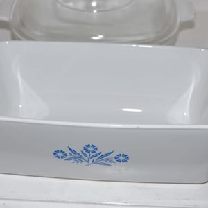 May include: White ceramic baking dish with a blue floral design. The dish is empty and ready to be used.