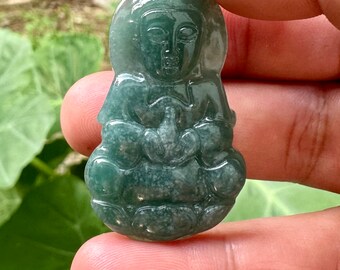 May include: A green jade pendant carved in the shape of a sitting Buddha. The pendant has a detailed face and intricate carvings.