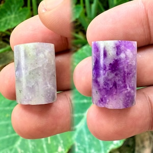 Puede incluir: Dos cabujones cilíndricos de fluorita púrpura y blanca. Los cabujones miden aproximadamente 2,5 cm de largo y tienen una superficie lisa y pulida.