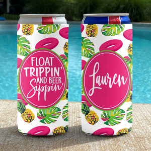 May include: Two white can coolers with a tropical print featuring pineapples, palm leaves, and pink inflatable rings. One cooler says "Float Trippin' and Beer Sippin'" and the other says "Lauren".