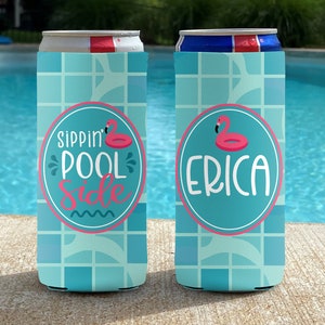 May include: Two blue and white can coolers with a pink flamingo pool float design. One cooler says "Sippin' Pool Side" and the other says "Erica".