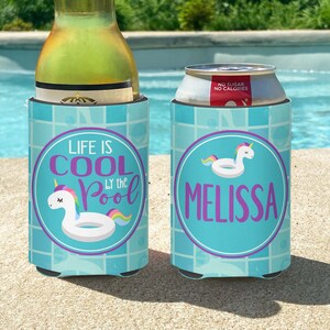 May include: Two blue and white can coolers with a unicorn pool float design. One cooler says "Life is Cool by the Pool" and the other says "Melissa".
