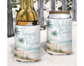 May include: Two white foam can coolers with a beach scene and palm trees. One cooler says "We did it on the beach" with the text "Key West, Florida August 24, 2023". The other cooler says "Thomas & Peyton".